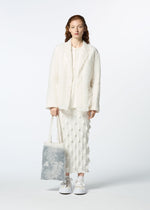 A model wears the HAAT GLASSLEAF TOTE JANUARY bags.