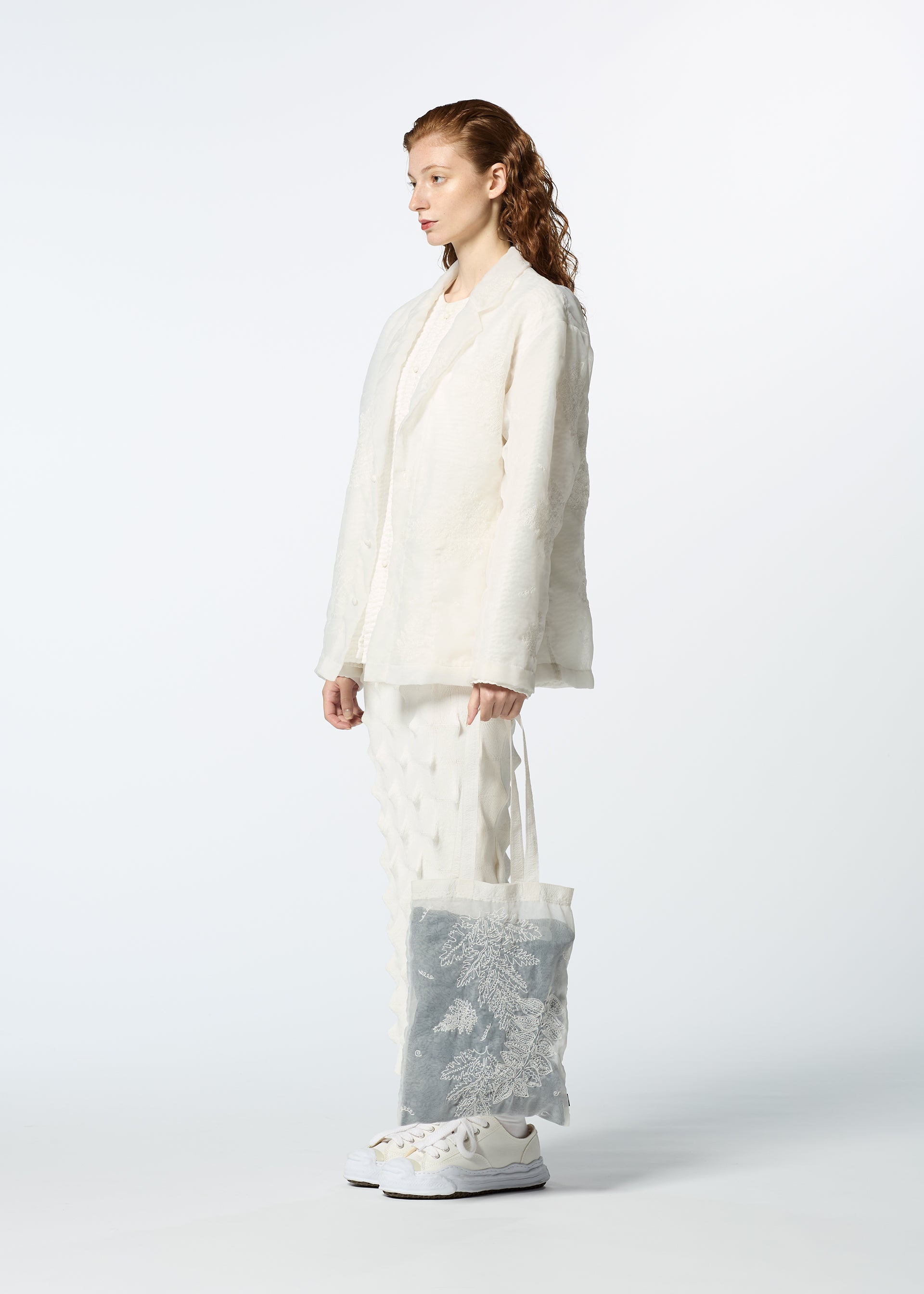 A model wears the HAAT GLASSLEAF TOTE JANUARY bags.