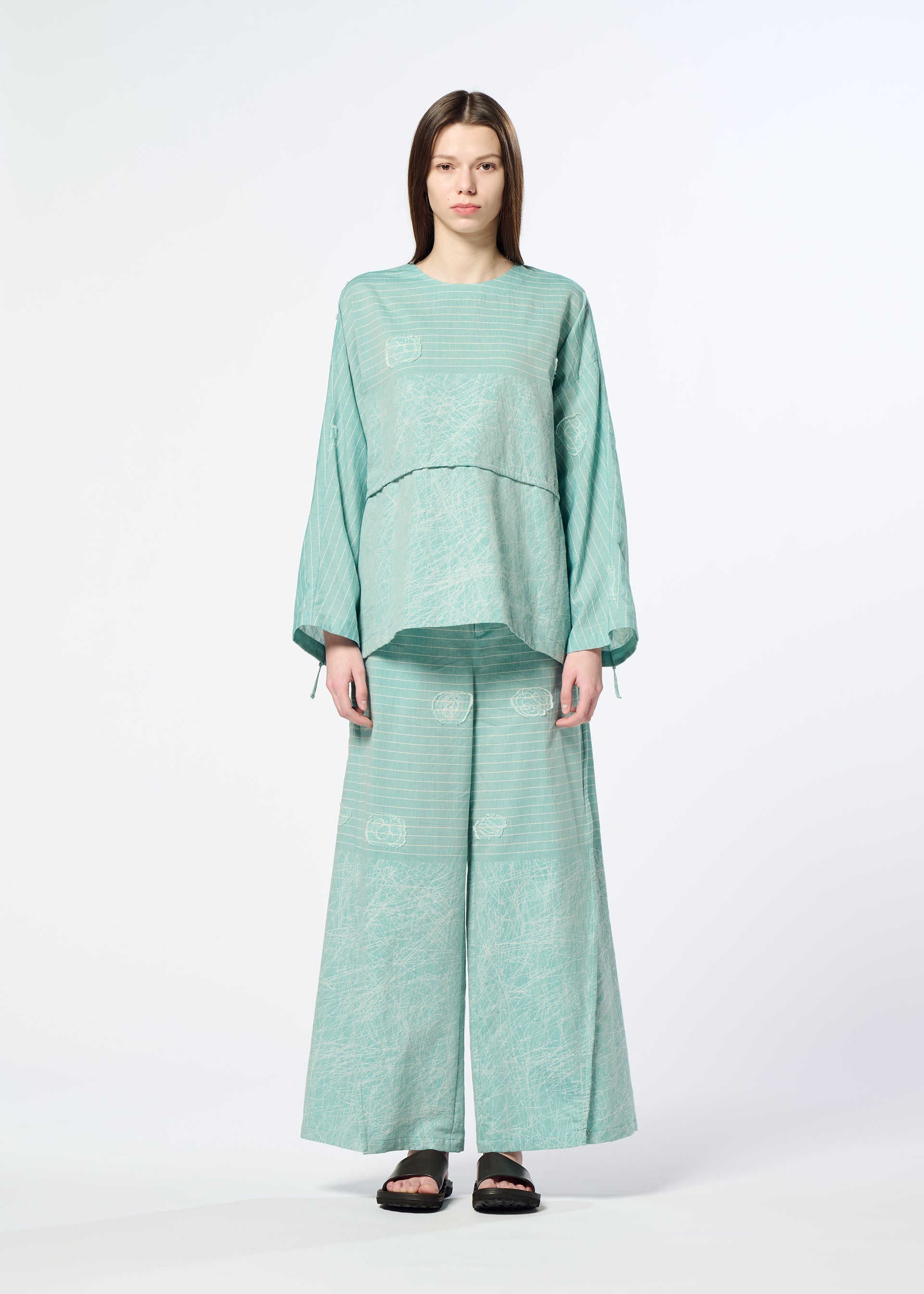 A model wears the HaaT ONE STROKE DRAW trousers.