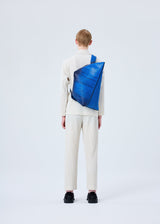 A model wears the HOMME PLISSÉ ISSEY MIYAKE RB_ALL OVER LAYER PRINT BAG bag.