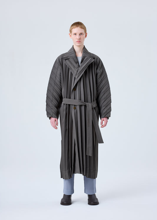 A model wears the HOMME PLISSÉ ISSEY MIYAKE  EDGE COAT coat