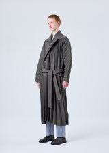 A model wears the HOMME PLISSÉ ISSEY MIYAKE  EDGE COAT coat