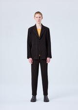 A model wears the HOMME PLISSÉ ISSEY MIYAKE KERSEY PLEATS trousers.