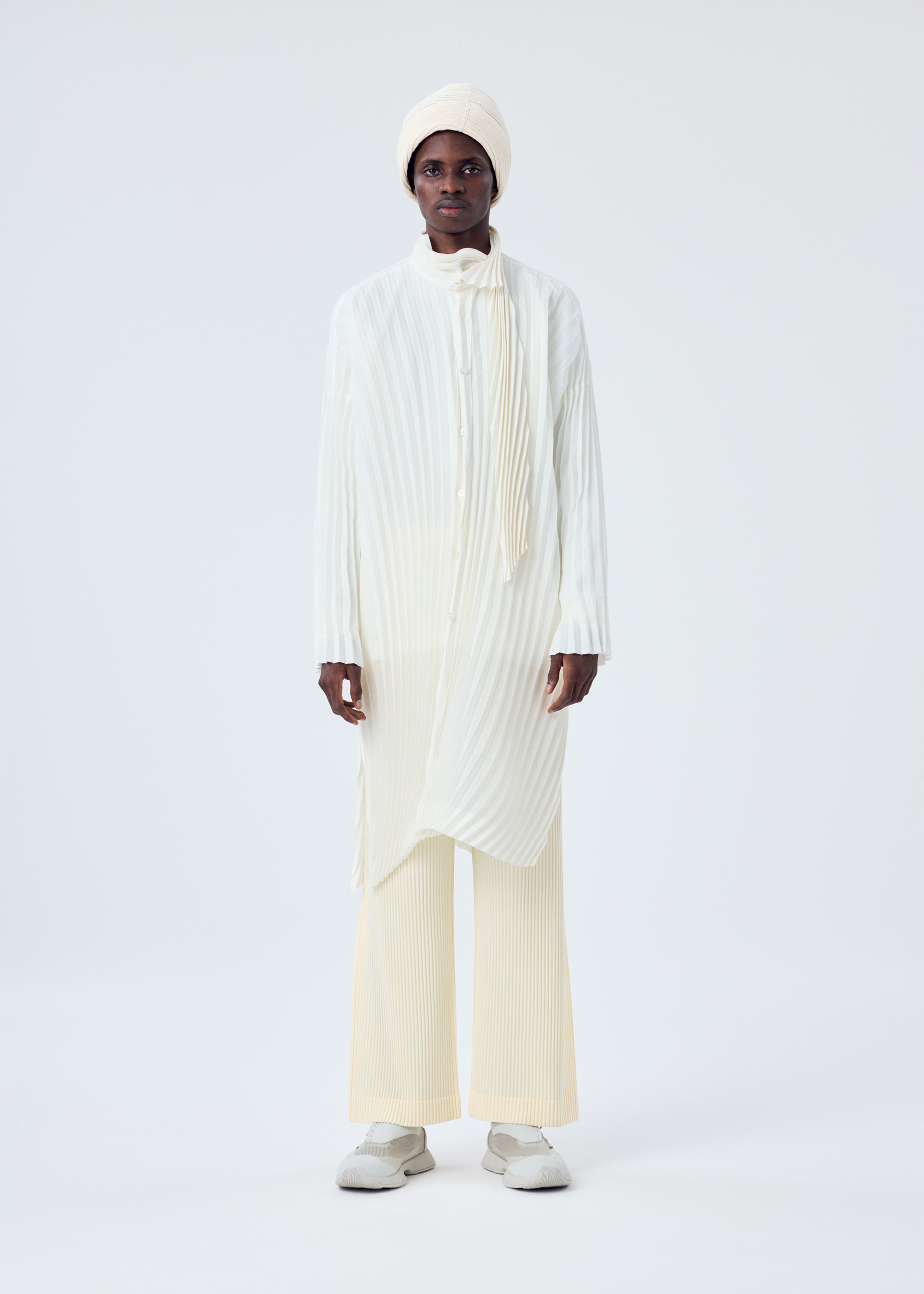 A model wears the HOMME PLISSÉ ISSEY MIYAKE BEANIE SCARF hat.