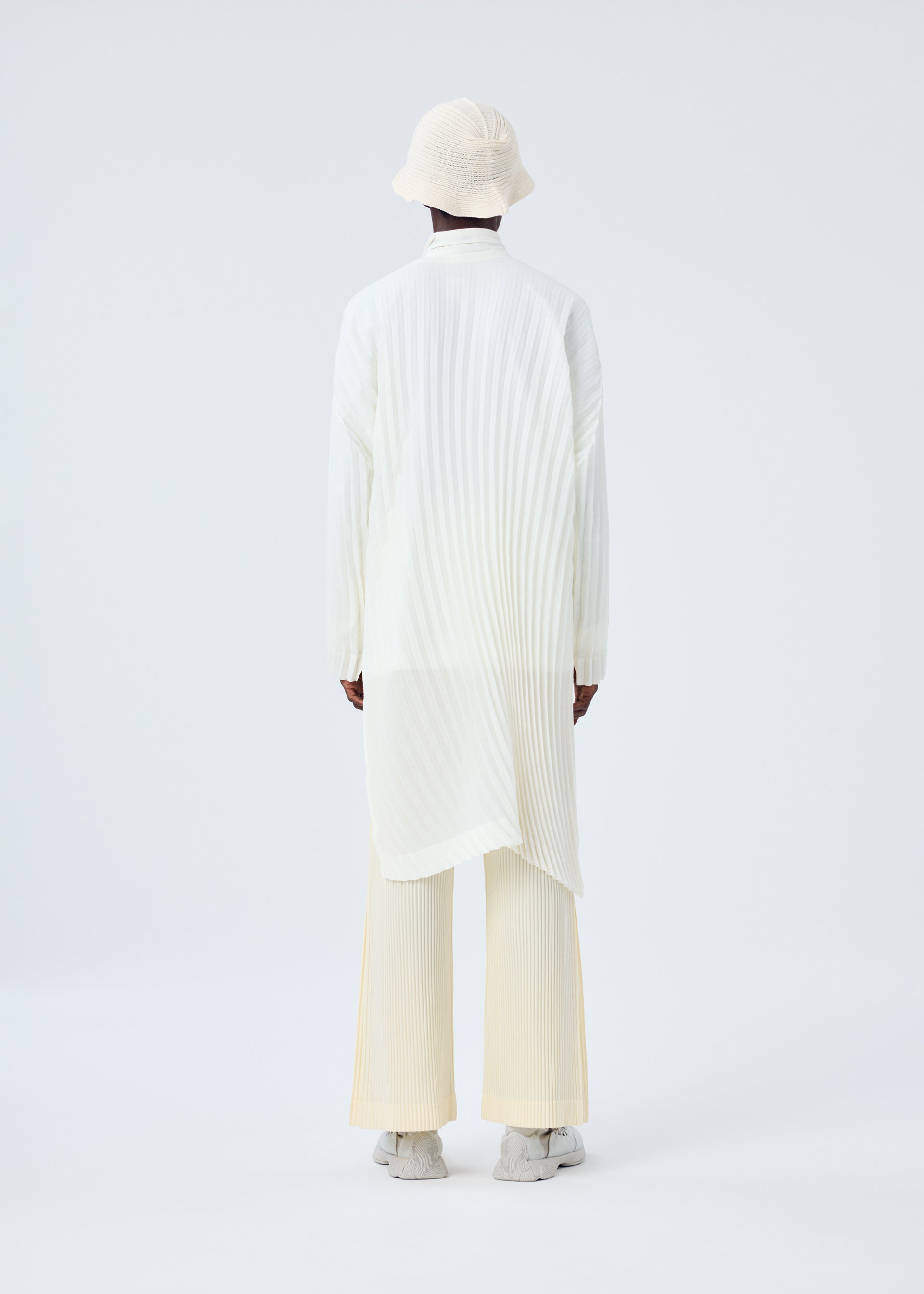 A model wears the HOMME PLISSÉ ISSEY MIYAKE BEANIE SCARF hat.