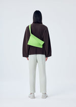 A model wears the HOMME PLISSÉ ISSEY MIYAKE OVERLAP bag.