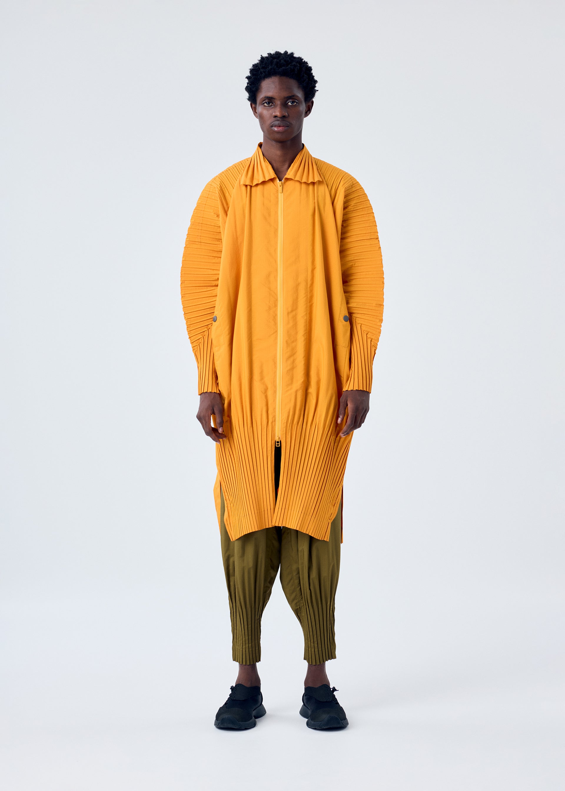 A model wears the HOMME PLISSÉ ISSEY MIYAKE CASCADE coat.