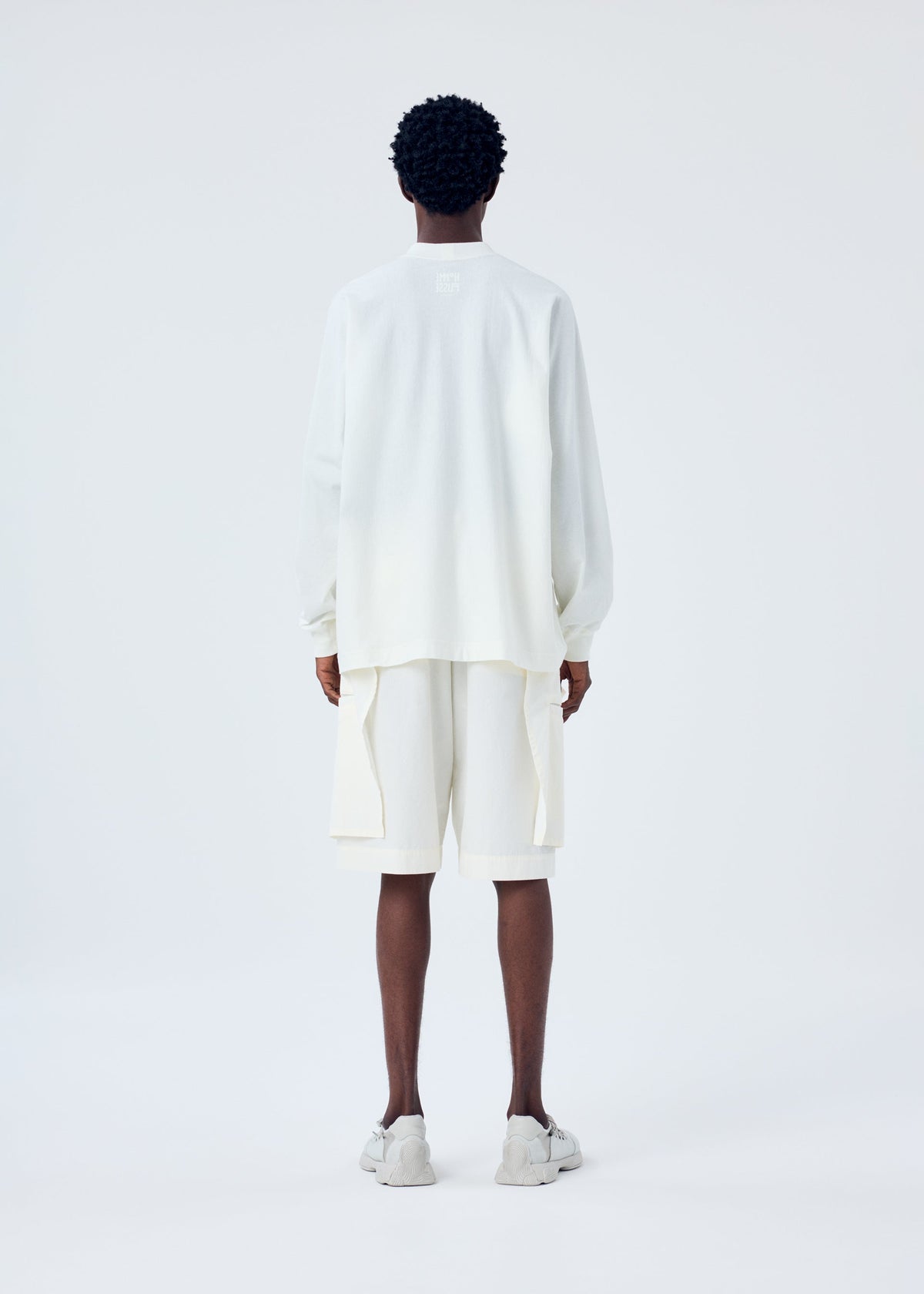 A model wears the HOMME PLISSÉ ISSEY MIYAKE FRESHEN trousers.