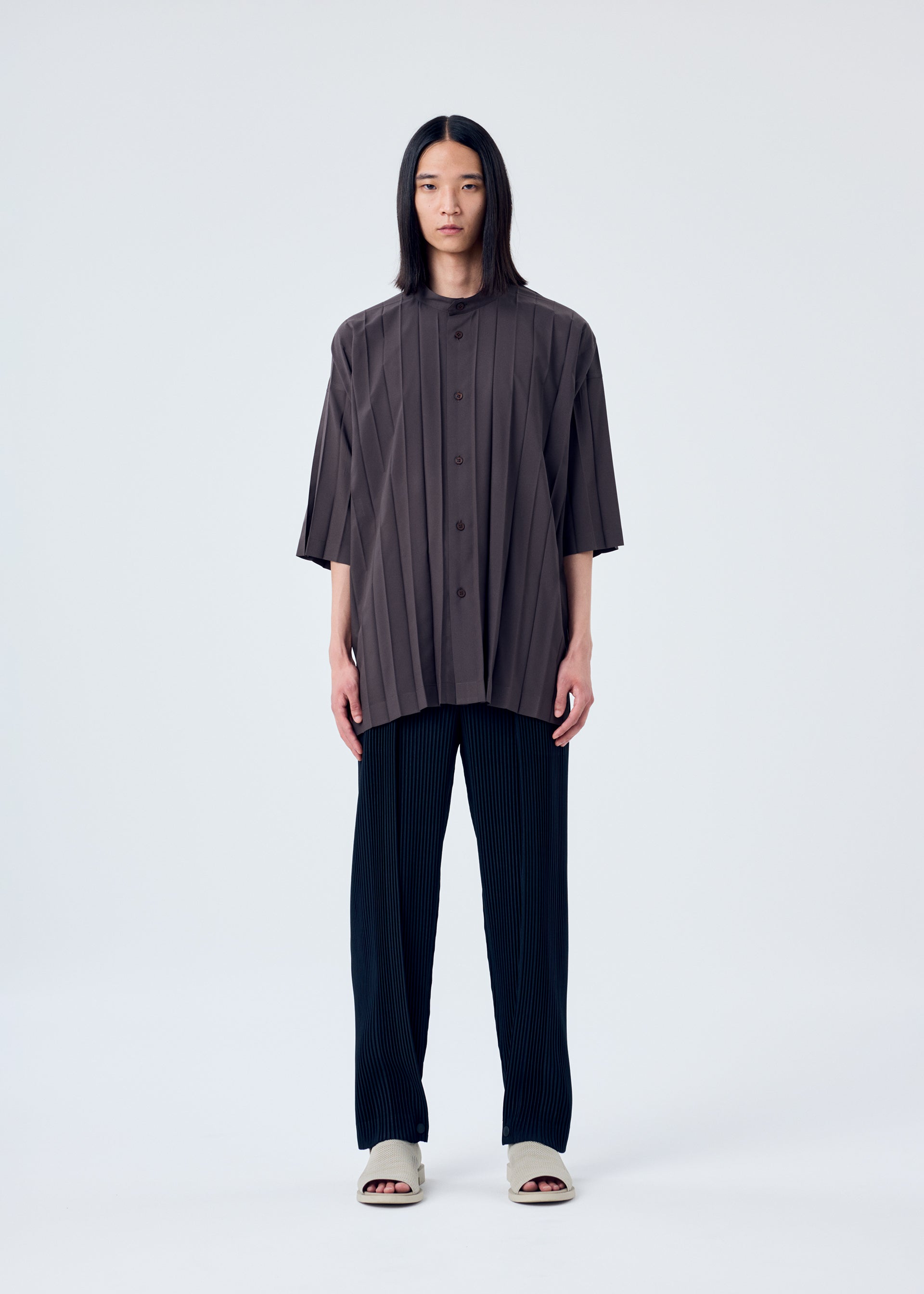 A model wears the HOMME PLISSÉ ISSEY MIYAKE EDGE SHIRT shirt.