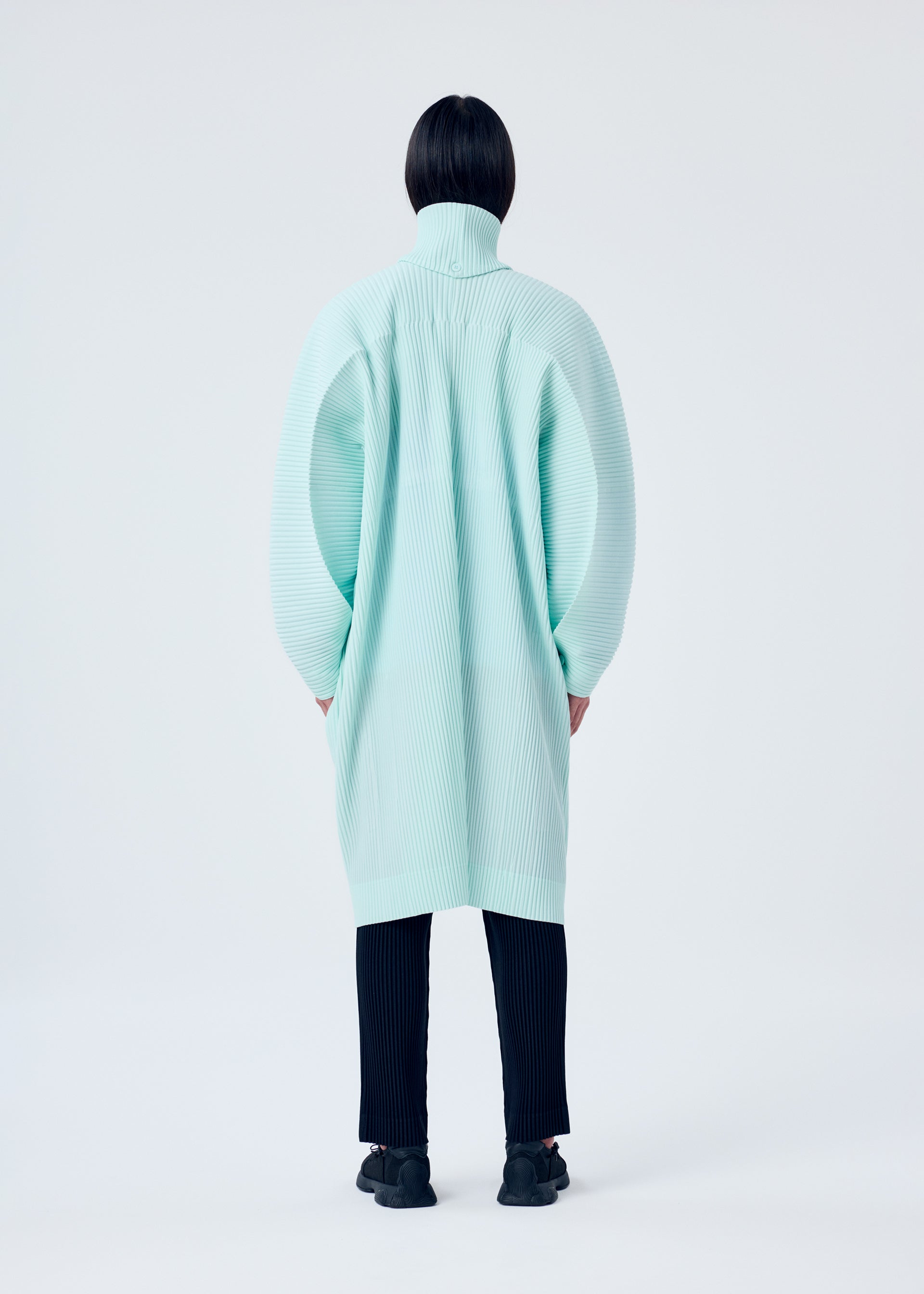 A model wears the HOMME PLISSÉ ISSEY MIYAKE MC JANUARY coat.