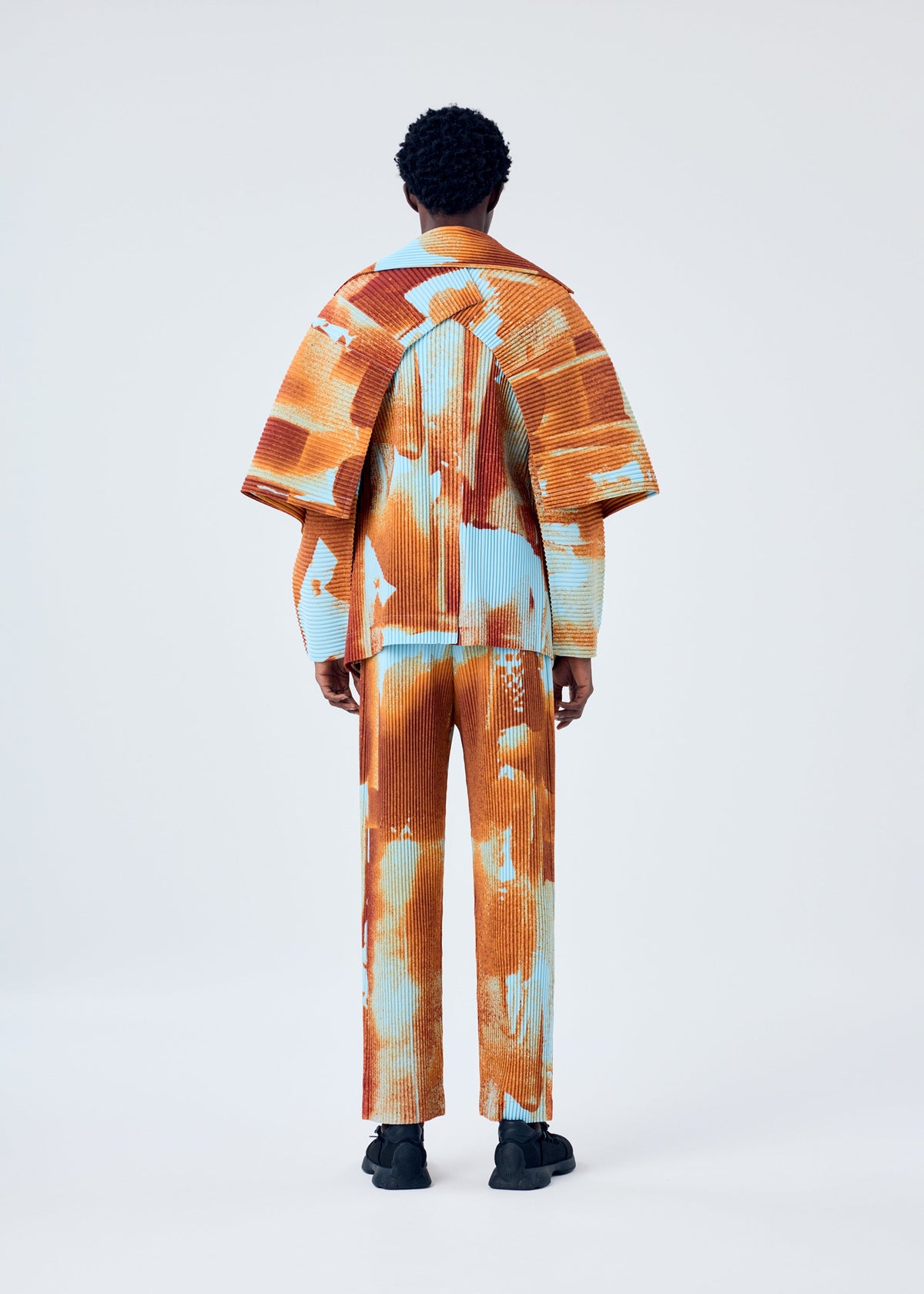 A model wears the HOMME PLISSÉ ISSEY MIYAKE WIND WALK jacket.