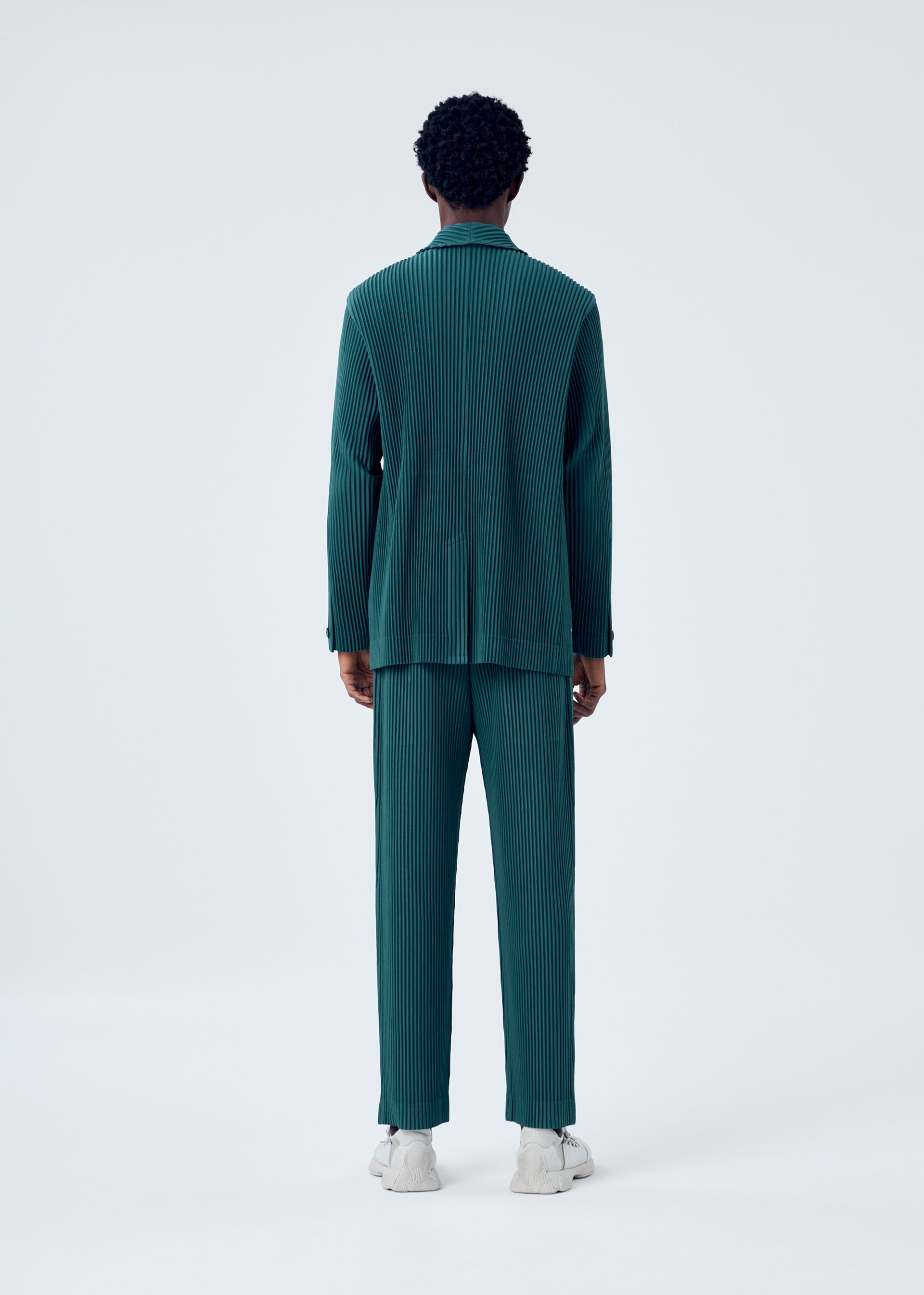 A model wears the HOMME PLISSÉ ISSEY MIYAKE TAILORED PLEATS 1 jacket.