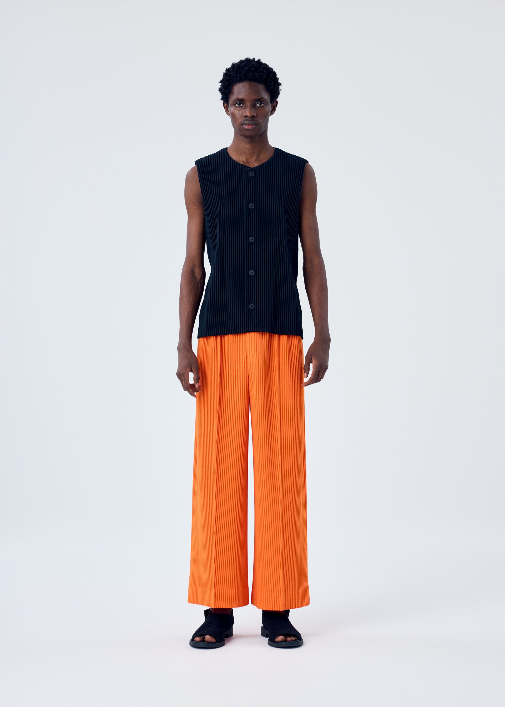 A model wears the HOMME PLISSÉ ISSEY MIYAKE MC FEBRUARY trousers.