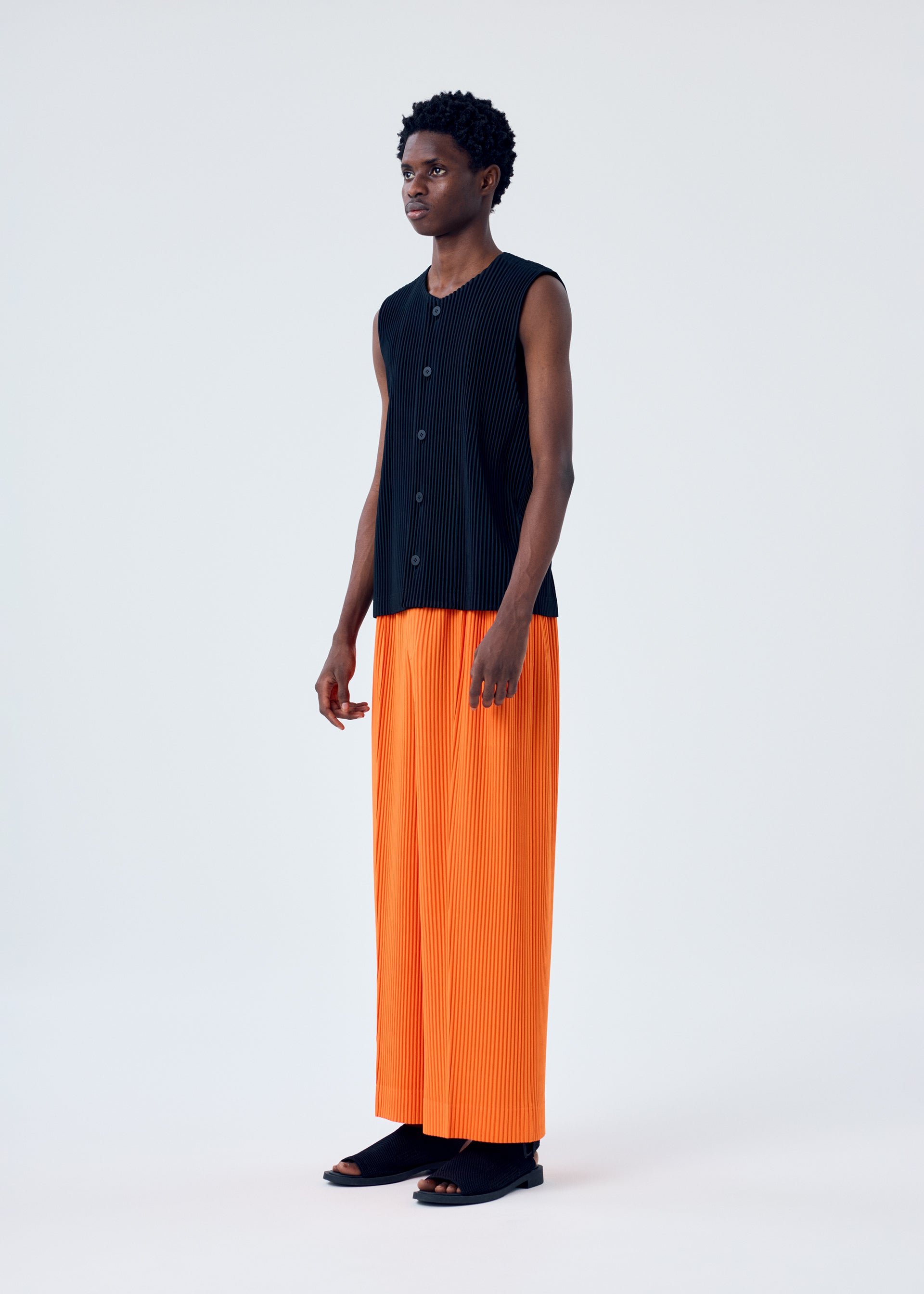 A model wears the HOMME PLISSÉ ISSEY MIYAKE MC FEBRUARY trousers.