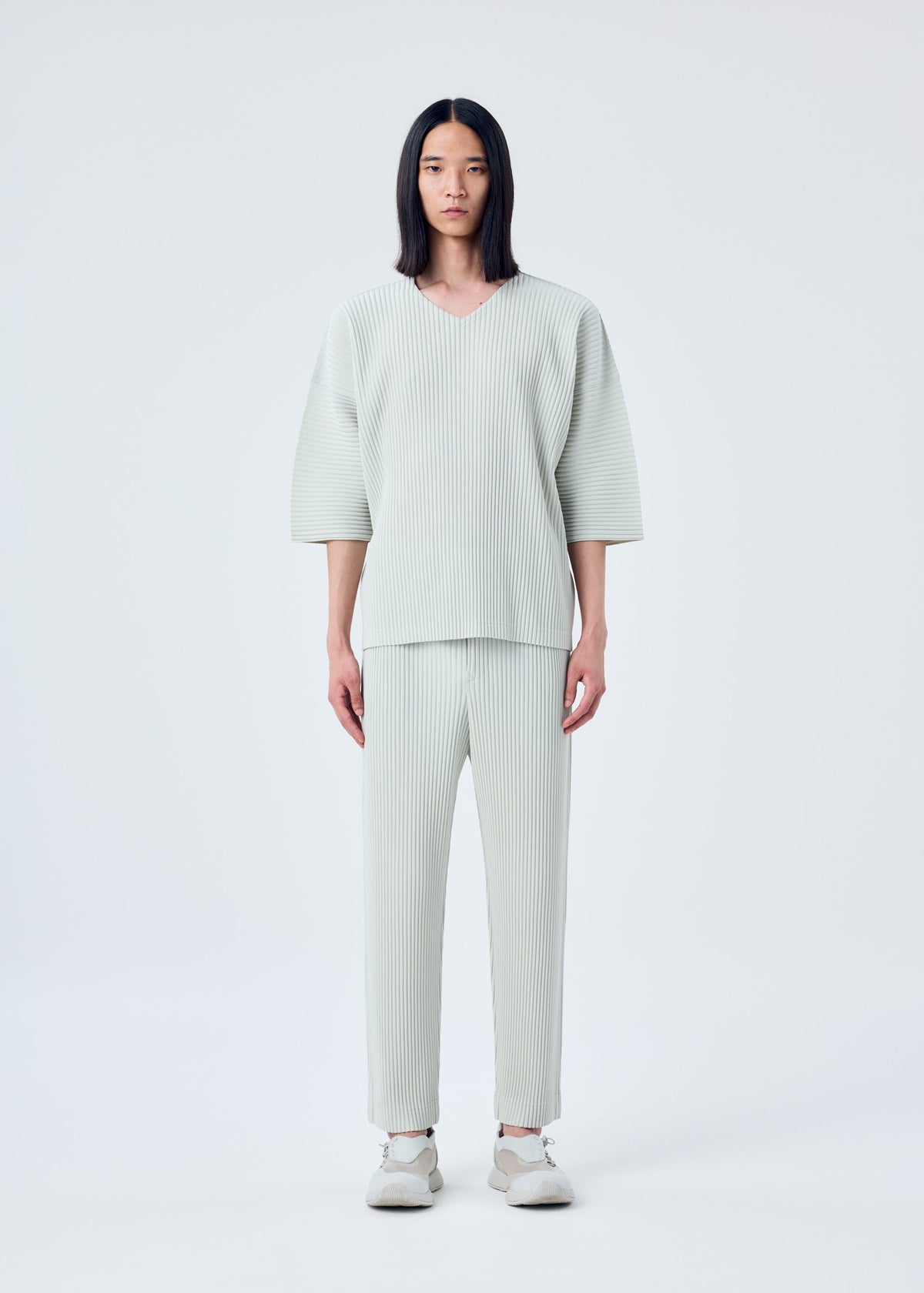 A model wears the HOMME PLISSÉ ISSEY MIYAKE MC MARCH trousers.