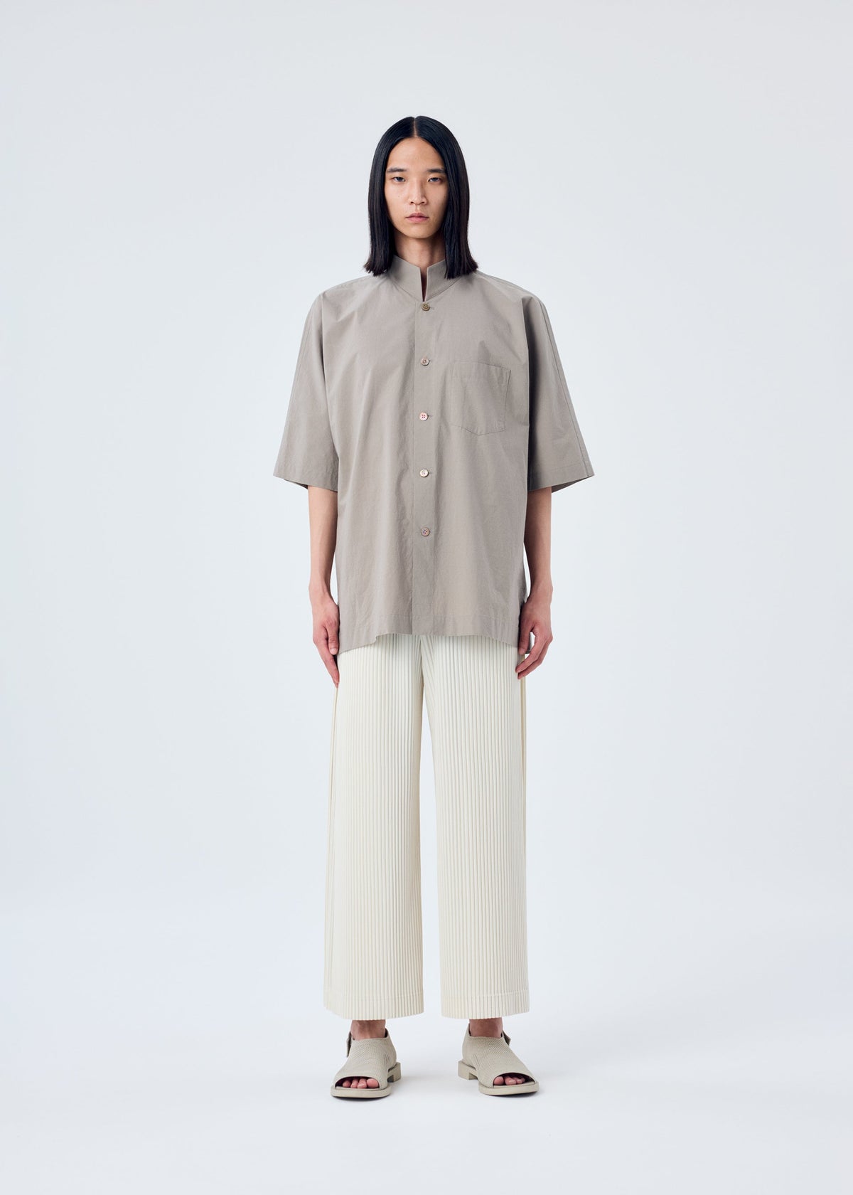 A model wears the HOMME PLISSÉ ISSEY MIYAKE MC MAY trousers.