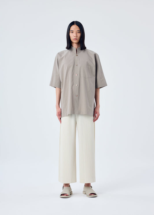 A model wears the HOMME PLISSÉ ISSEY MIYAKE MC MAY trousers.