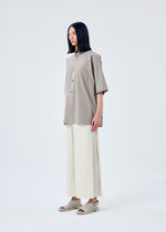 A model wears the HOMME PLISSÉ ISSEY MIYAKE MC MAY trousers.