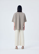 A model wears the HOMME PLISSÉ ISSEY MIYAKE MC MAY trousers.