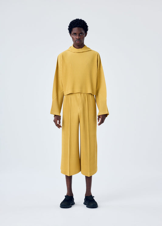 A model wears the HOMME PLISSÉ ISSEY MIYAKE MC JUNE trousers.