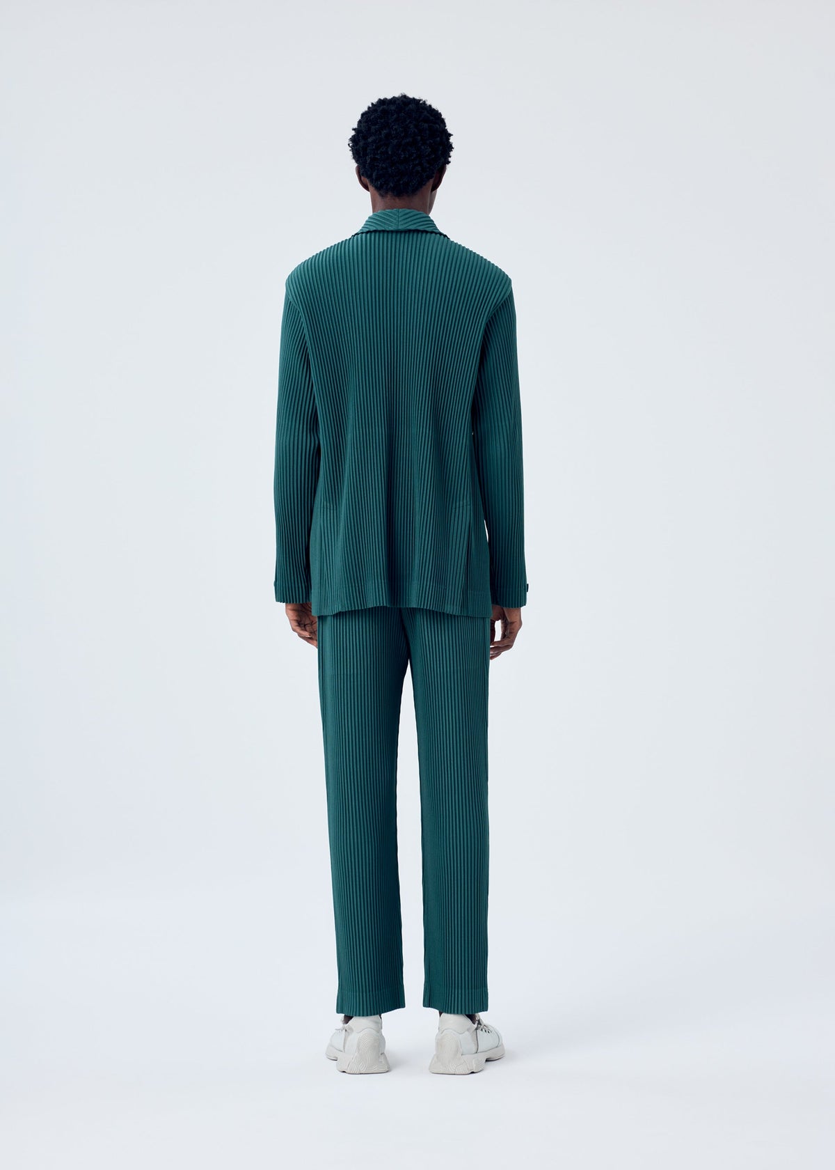 A model wears the HOMME PLISSÉ ISSEY MIYAKE TAILORED PLEATS 1 trousers.