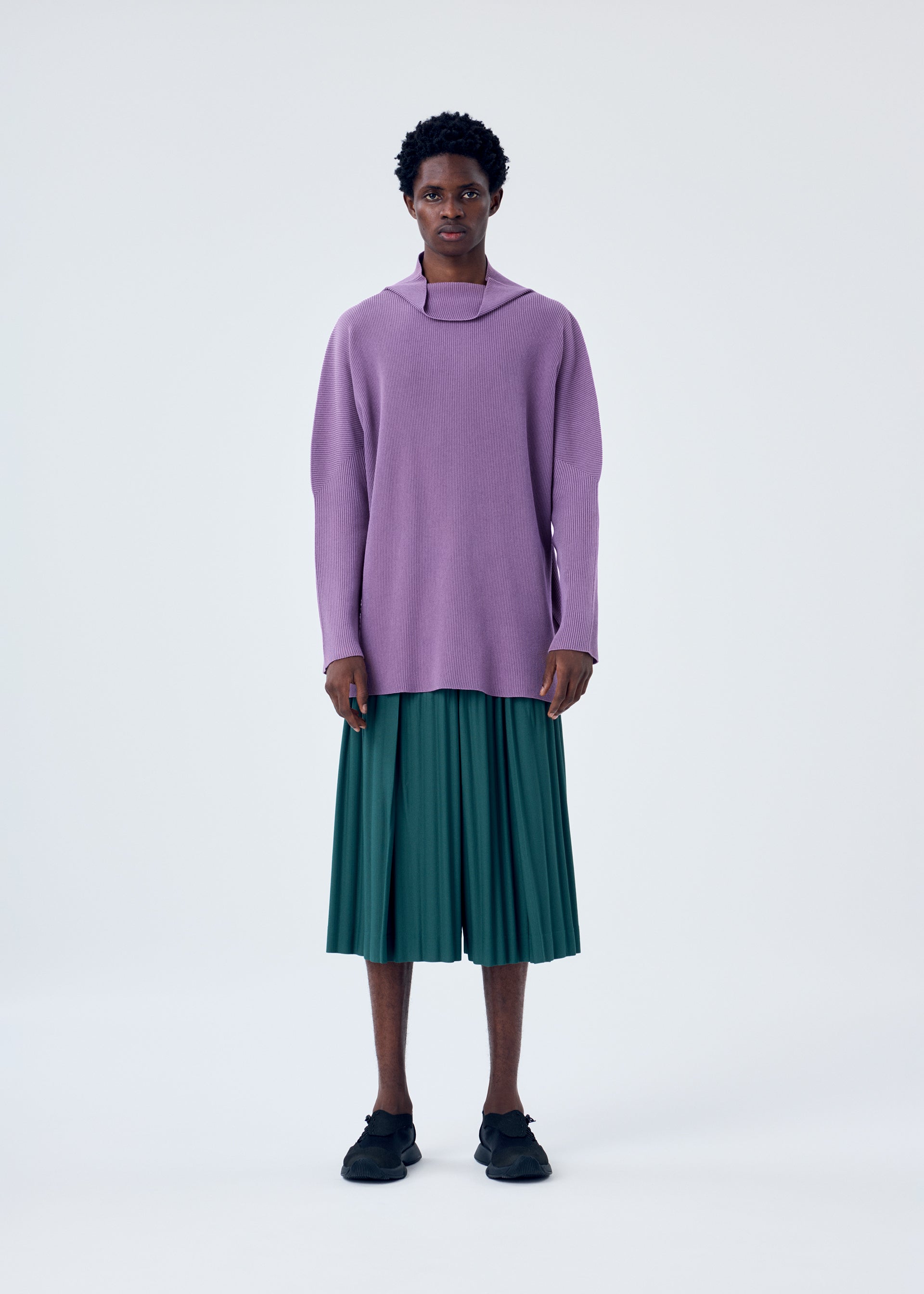 A model wears the HOMME PLISSÉ ISSEY MIYAKE TAILORED PLEATS 1 trousers.