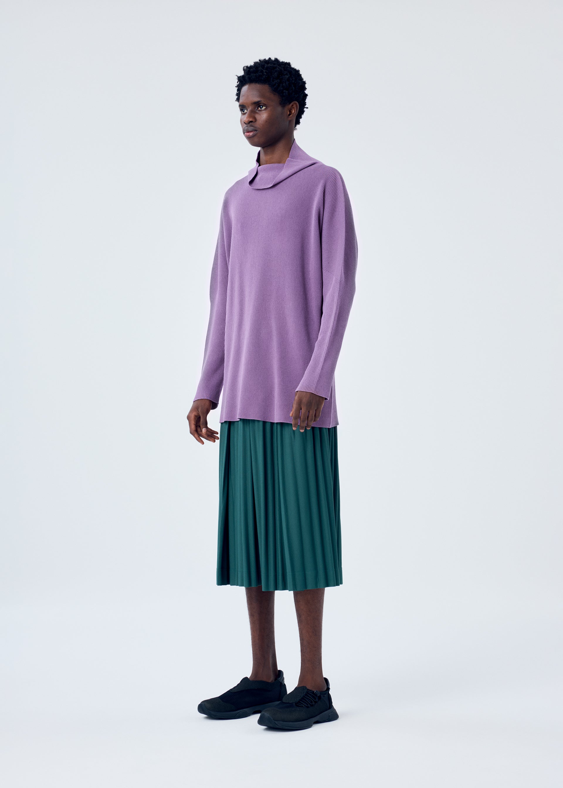 A model wears the HOMME PLISSÉ ISSEY MIYAKE TAILORED PLEATS 1 trousers.