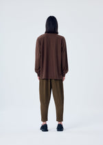 A model wears the HOMME PLISSÉ ISSEY MIYAKE HEATHER PLEATS trousers.