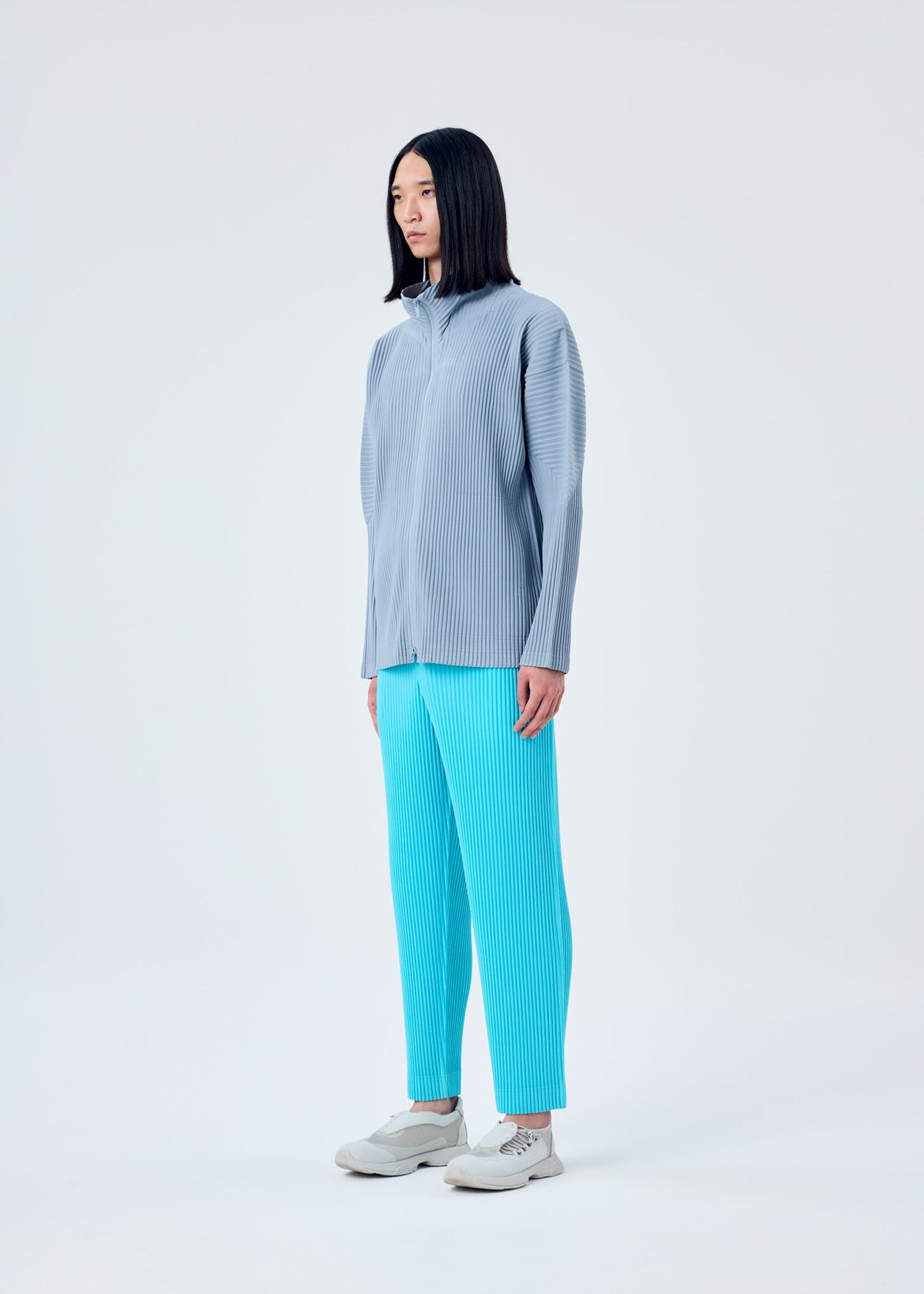 A model wears the HOMME PLISSÉ ISSEY MIYAKE COLOR PLEATS trousers.