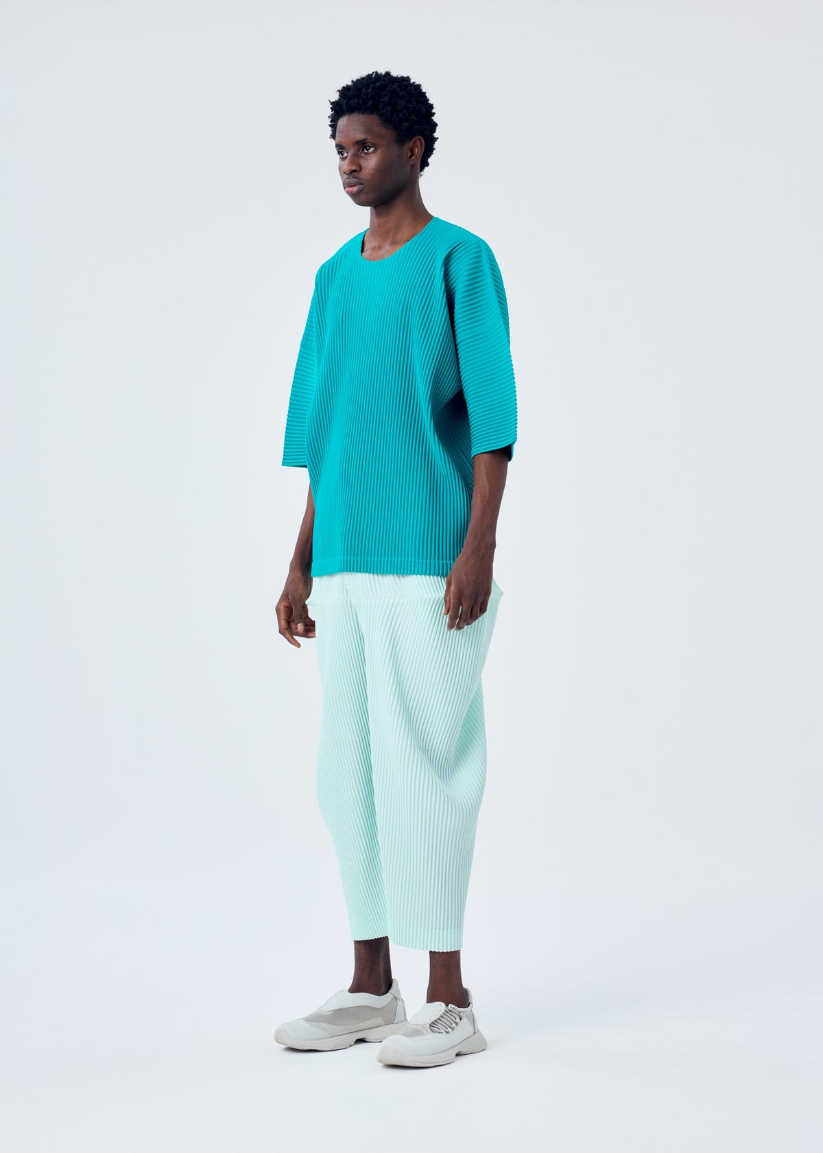 A model wears the HOMME PLISSÉ ISSEY MIYAKE KINETIC SCULPTURE trousers.
