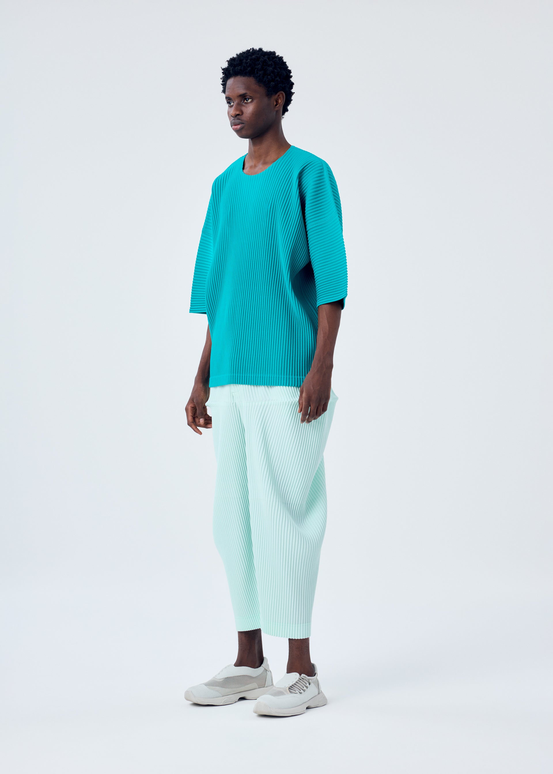 A model wears the HOMME PLISSÉ ISSEY MIYAKE KINETIC SCULPTURE trousers.