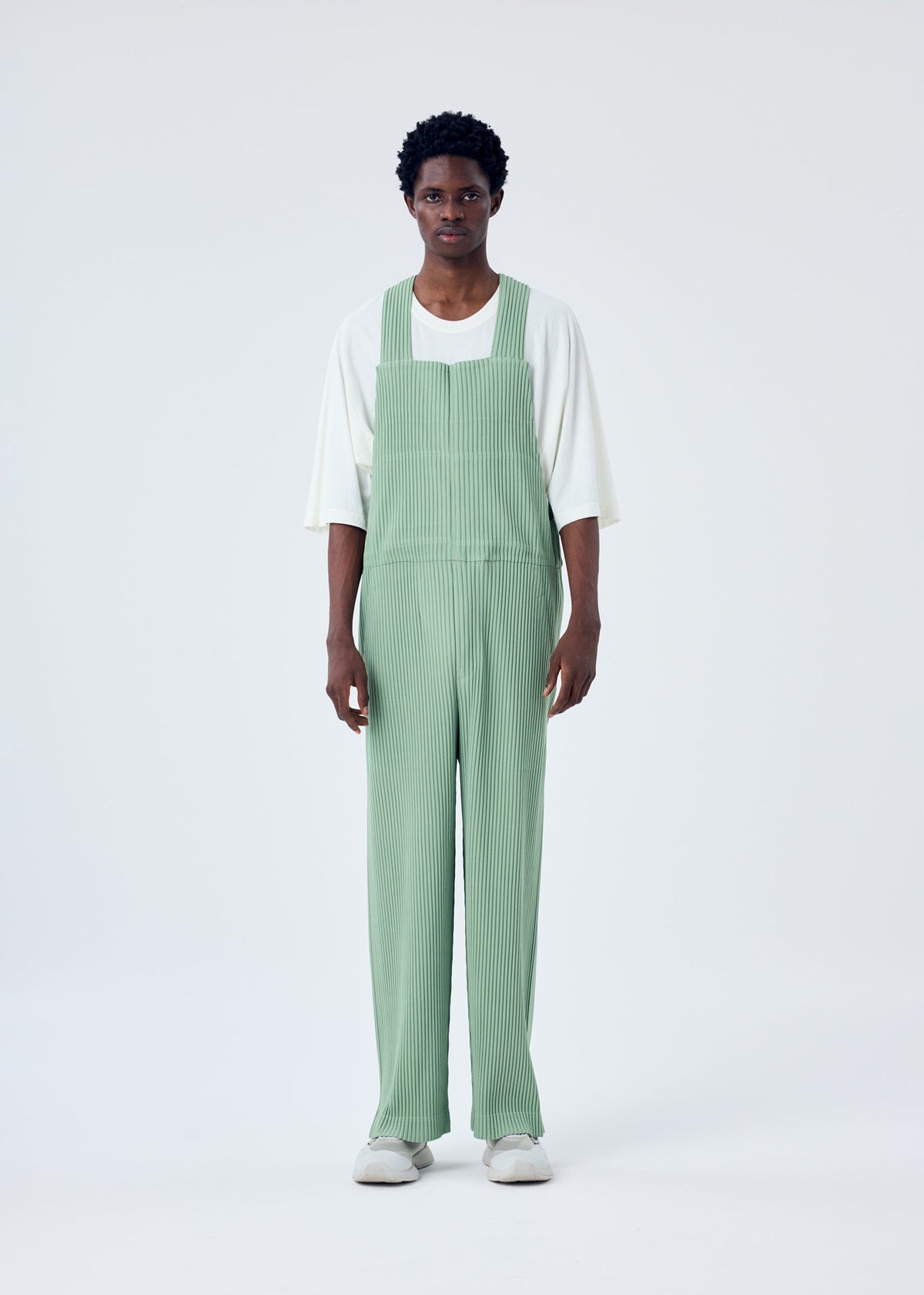 A model wears the HOMME PLISSÉ ISSEY MIYAKE PLEATS BOTTOMS 1 jumpsuit.