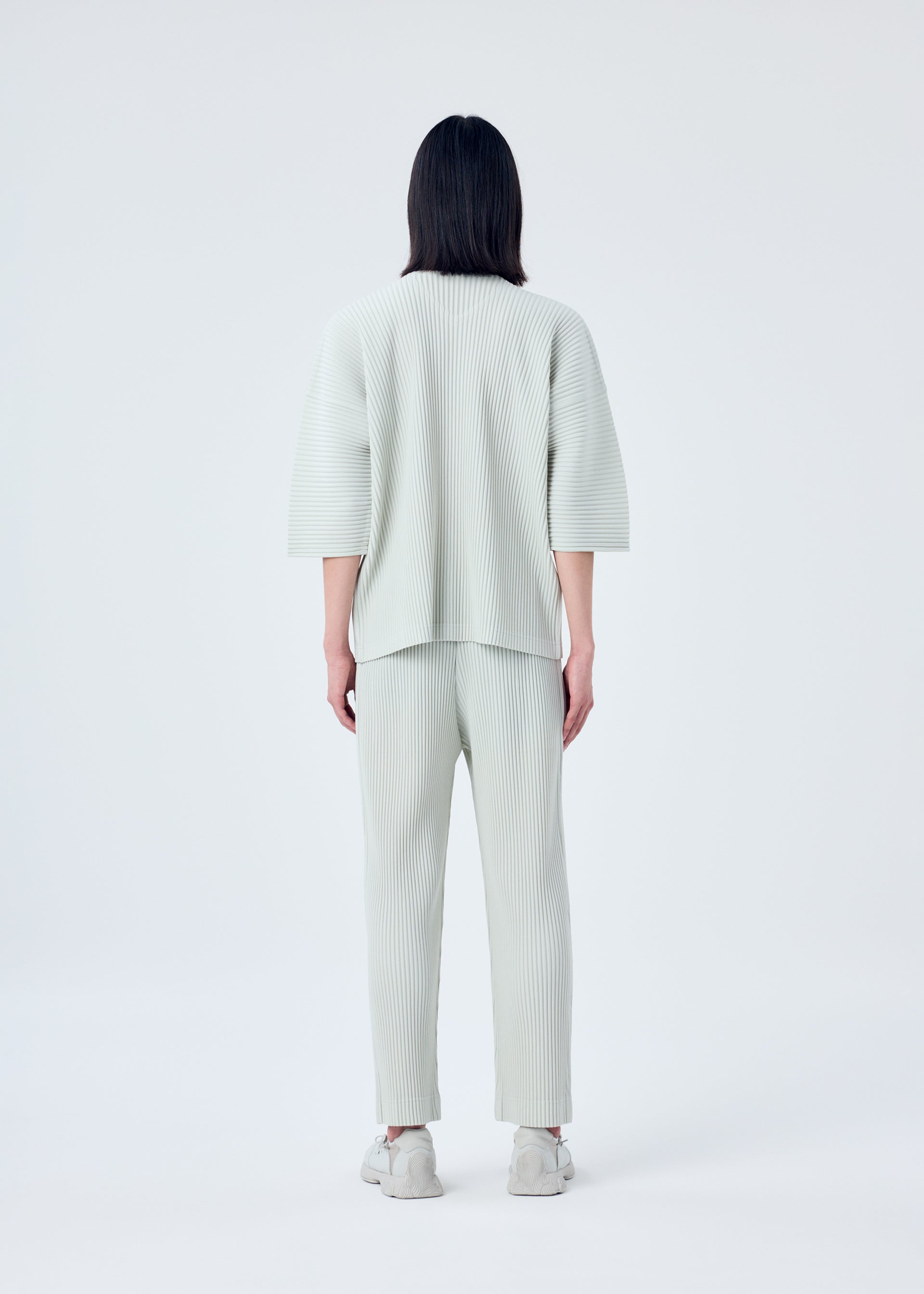 A model wears the HOMME PLISSÉ ISSEY MIYAKE MC MARCH top.