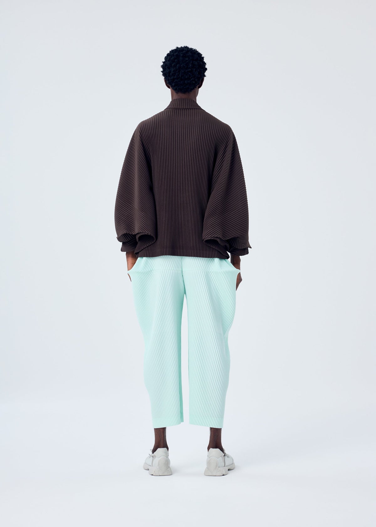 A model wears the HOMME PLISSÉ ISSEY MIYAKE KINETIC SCULPTURE top.