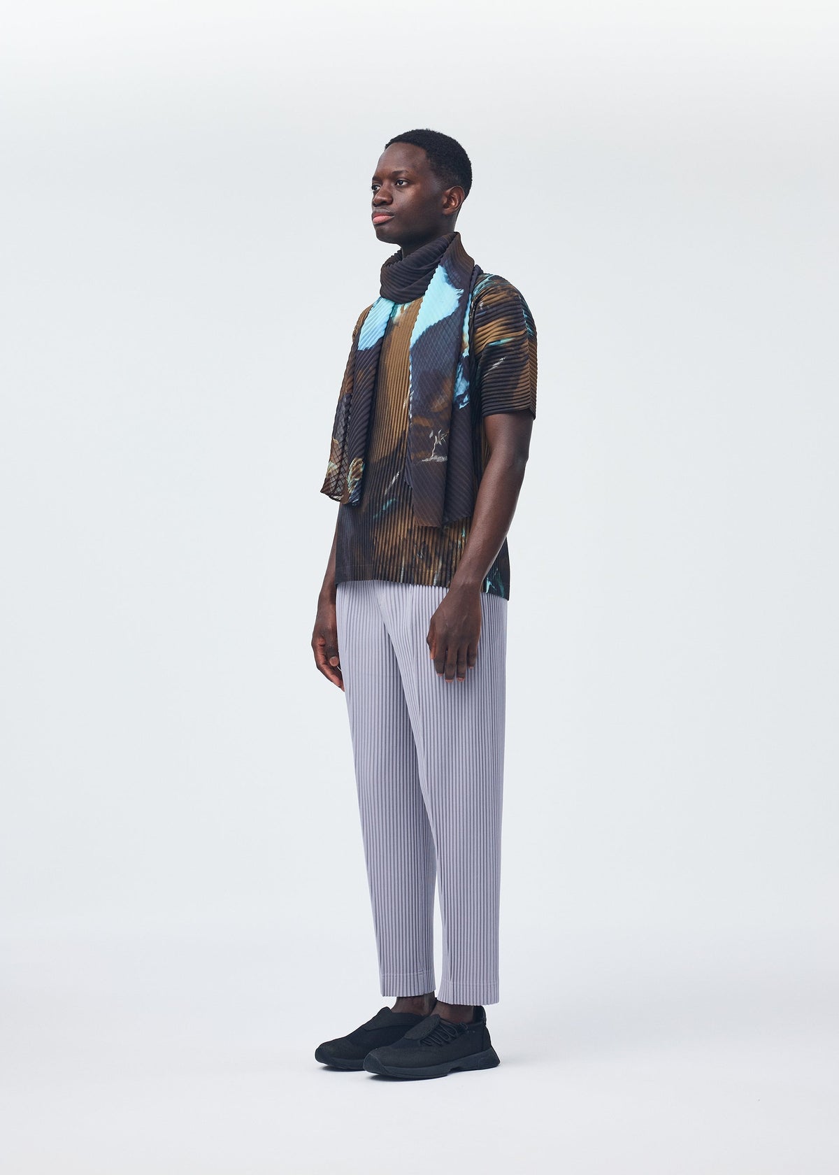 A model wears the HOMME PLISSÉ ISSEY MIYAKE AGATE SCARF stole.