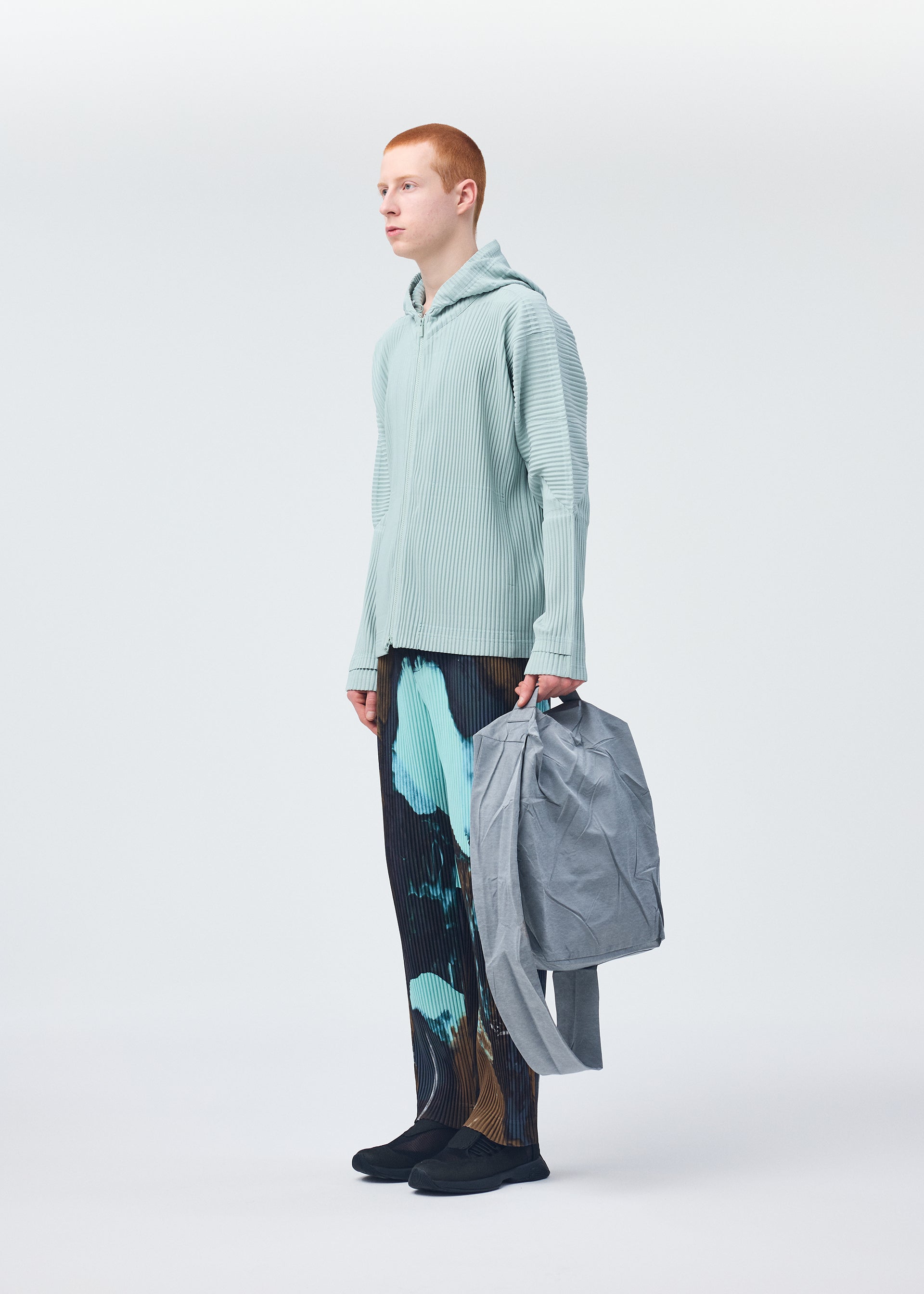 A model wears the HOMME PLISSÉ ISSEY MIYAKE STONE BAG bag.