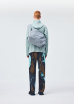 A model wears the HOMME PLISSÉ ISSEY MIYAKE STONE BAG bag.