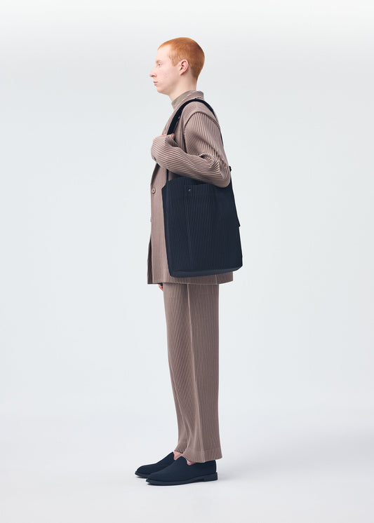 A model wears the HOMME PLISSÉ ISSEY MIYAKE UTILITY bag.