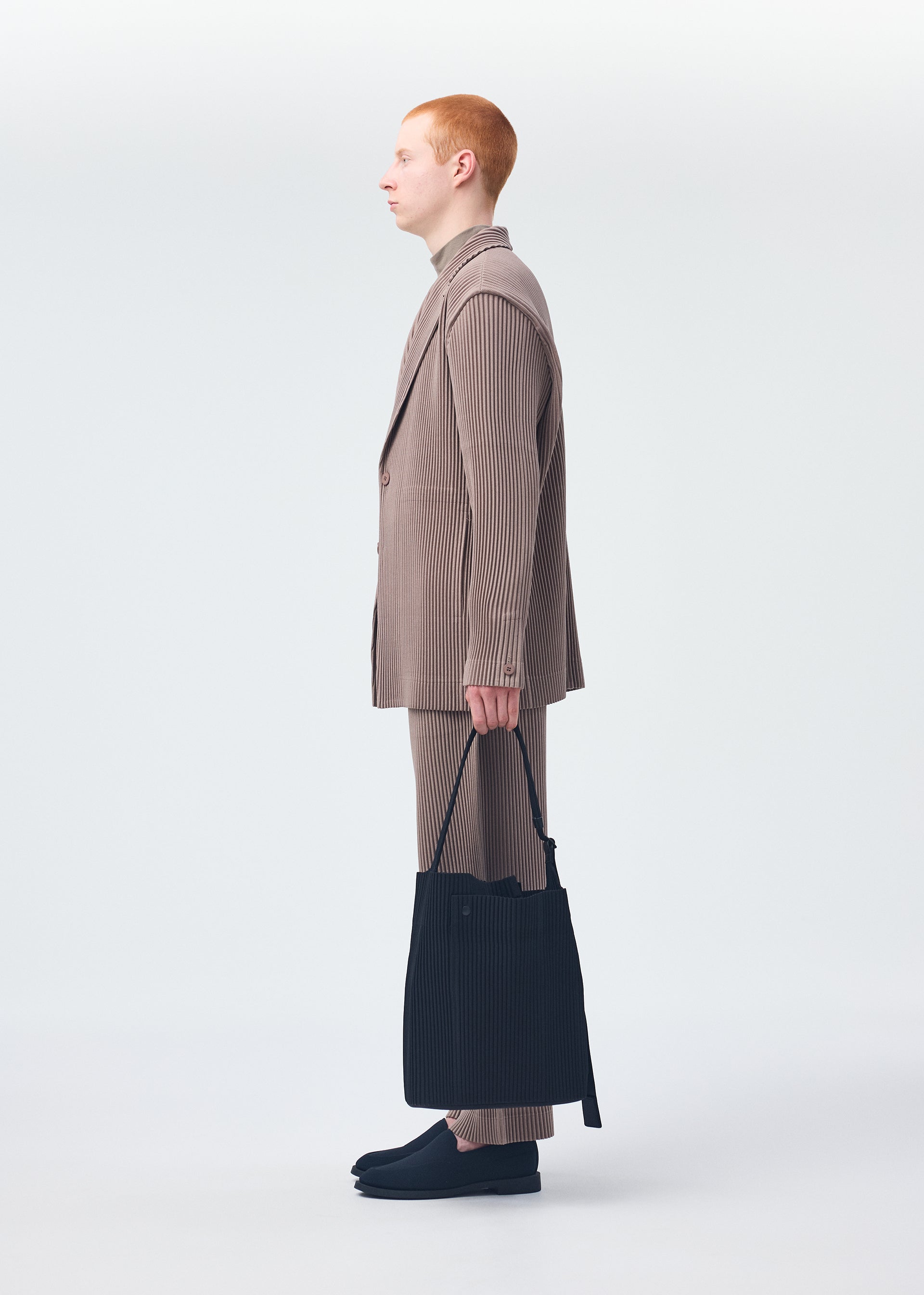 A model wears the HOMME PLISSÉ ISSEY MIYAKE UTILITY bag.
