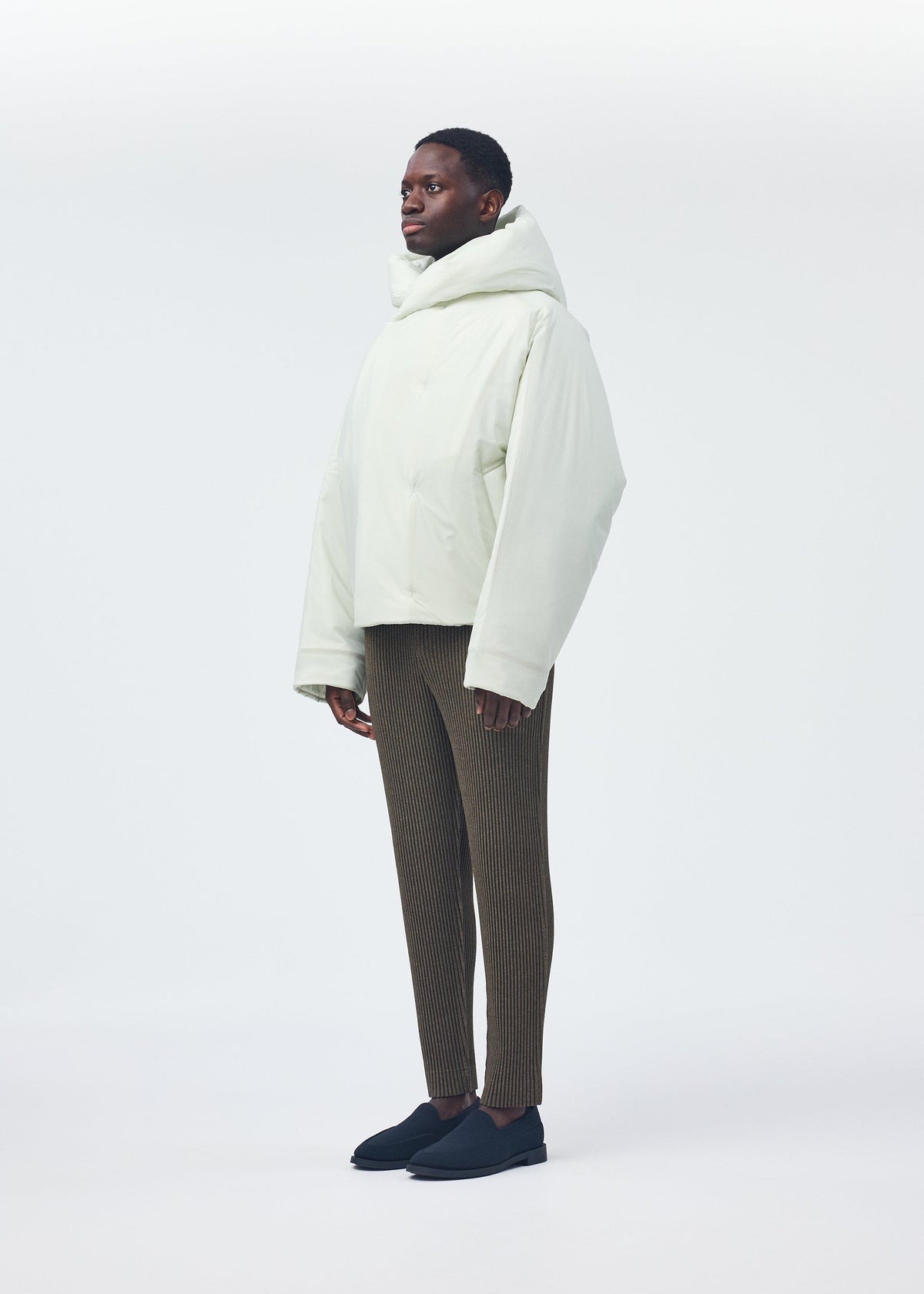 A model wears the HOMME PLISSÉ ISSEY MIYAKE DUVET COAT jacket.