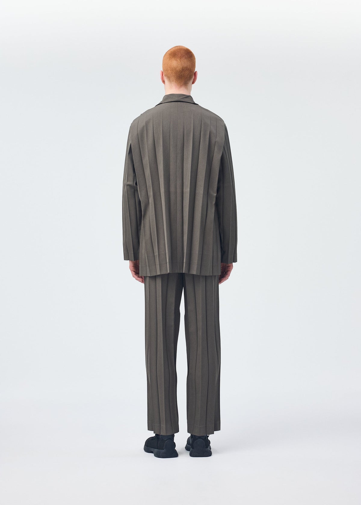A model wears the HOMME PLISSÉ ISSEY MIYAKE EDGE ENSEMBLE jacket.