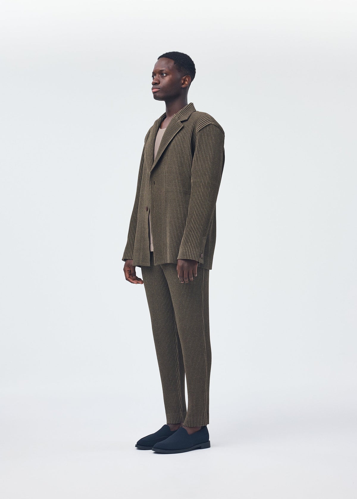 A model wears the HOMME PLISSÉ ISSEY MIYAKE WOOL LIKE LIGHT jacket.