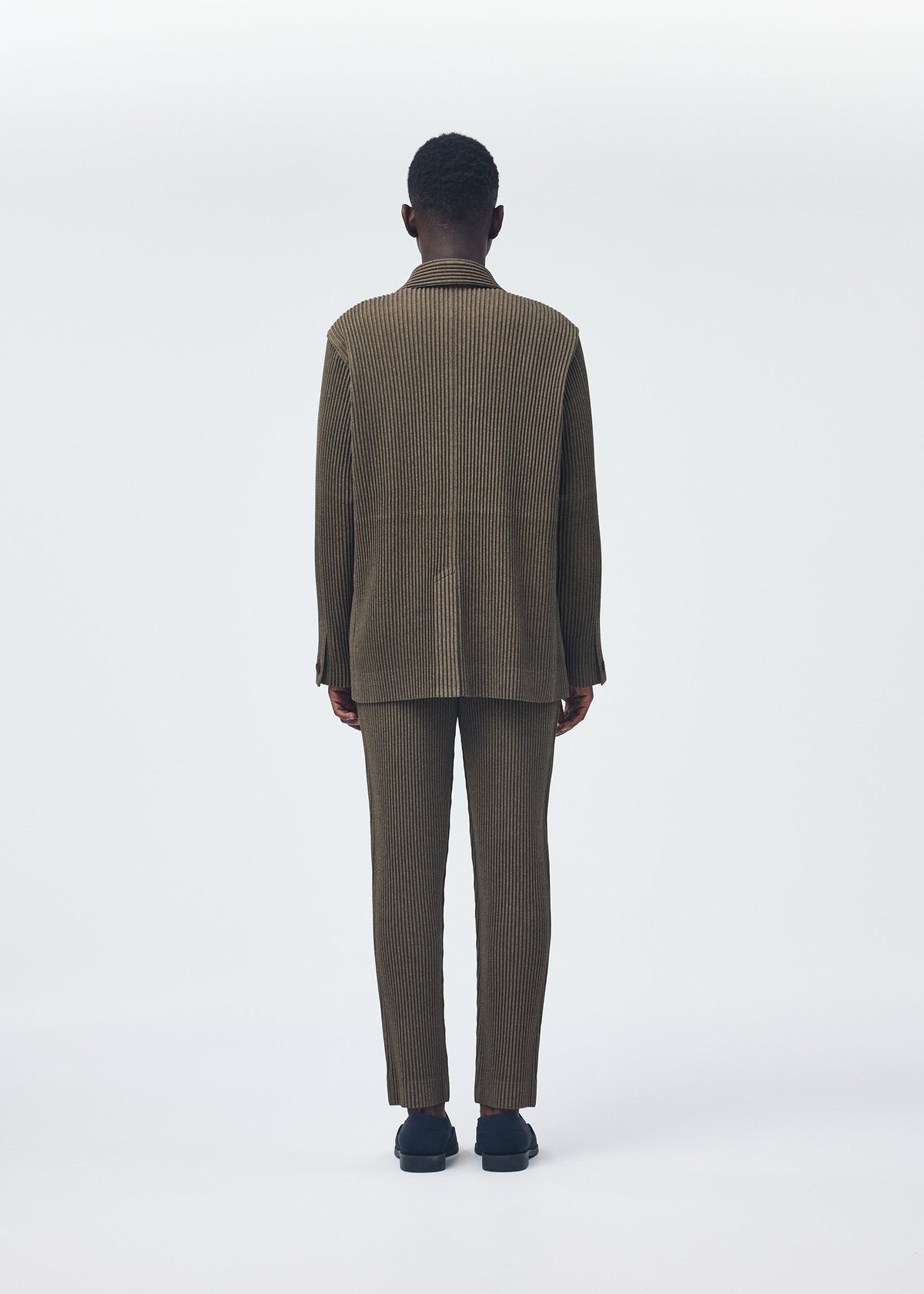 A model wears the HOMME PLISSÉ ISSEY MIYAKE WOOL LIKE LIGHT jacket.