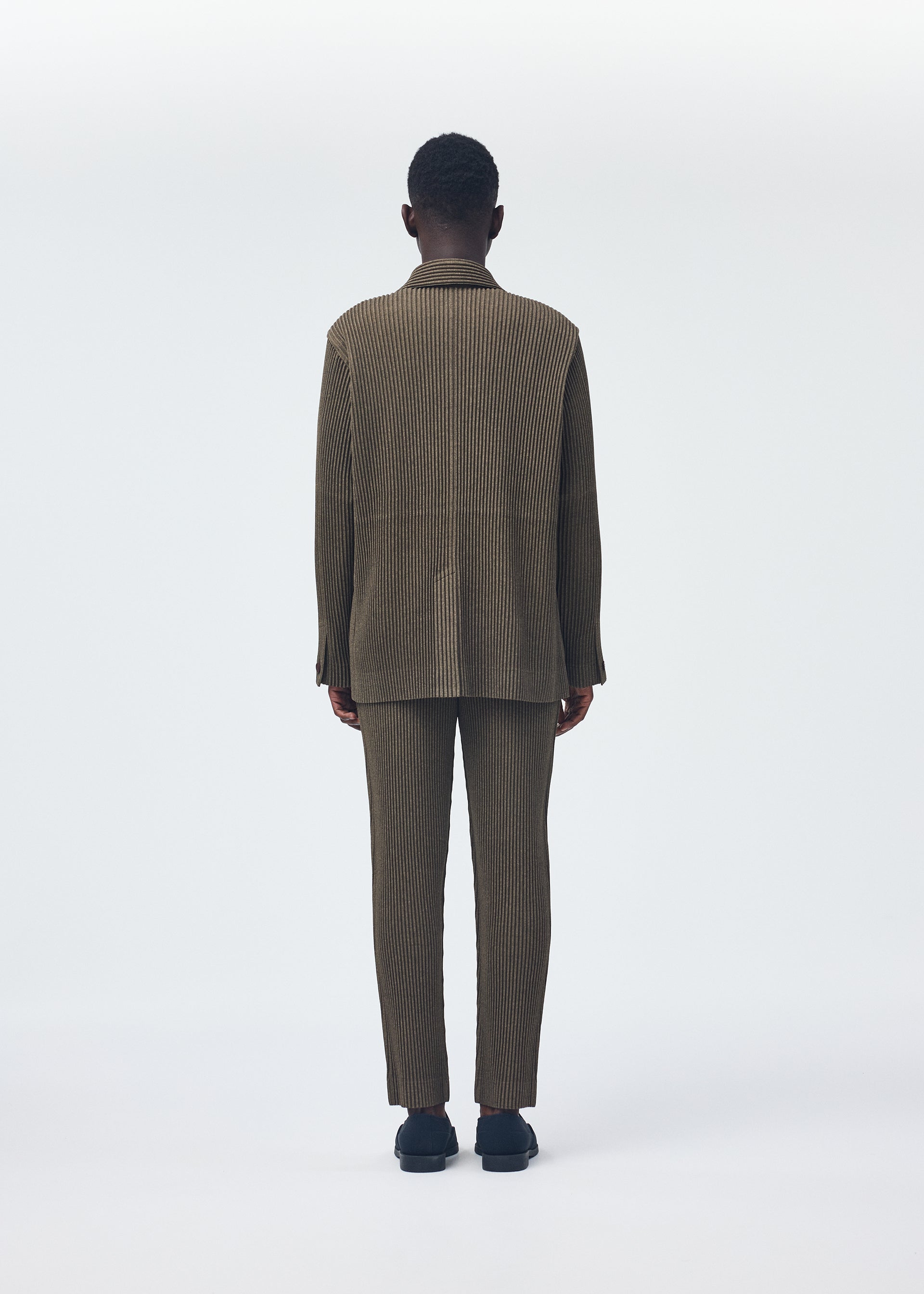 A model wears the HOMME PLISSÉ ISSEY MIYAKE WOOL LIKE LIGHT jacket.