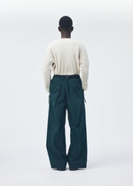 A model wears the HOMME PLISSÉ ISSEY MIYAKE QUARRY PANTS trousers.