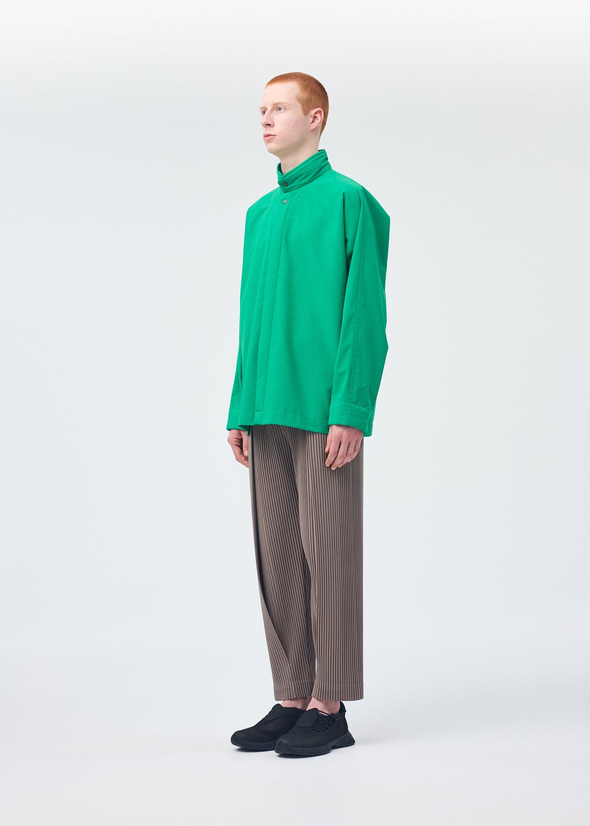 A model wears the HOMME PLISSÉ ISSEY MIYAKE PADDED RIM SHIRT shirt.