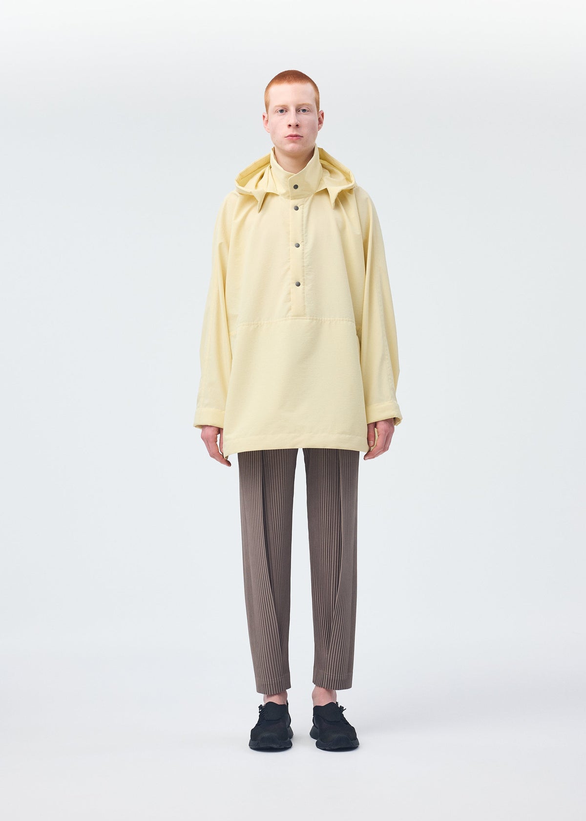A model wears the HOMME PLISSÉ ISSEY MIYAKE PADDED RIM SHIRT shirt.