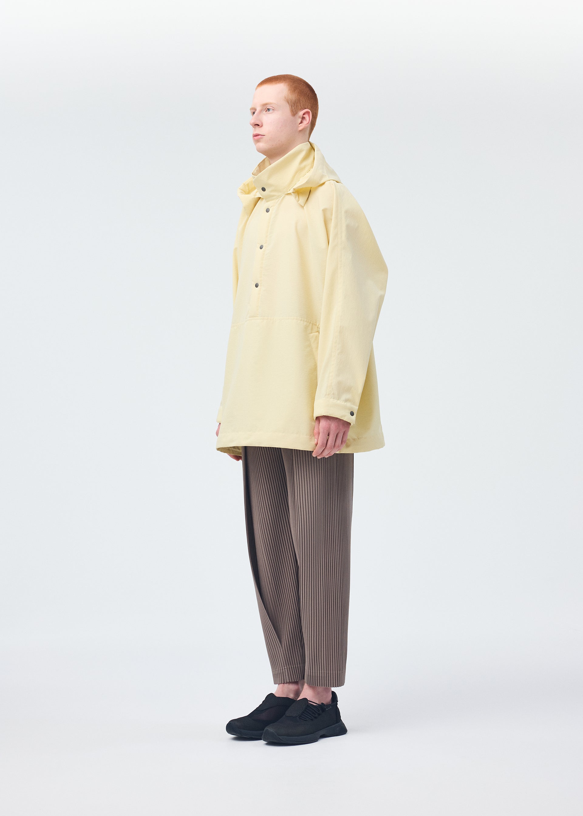 A model wears the HOMME PLISSÉ ISSEY MIYAKE PADDED RIM SHIRT shirt.