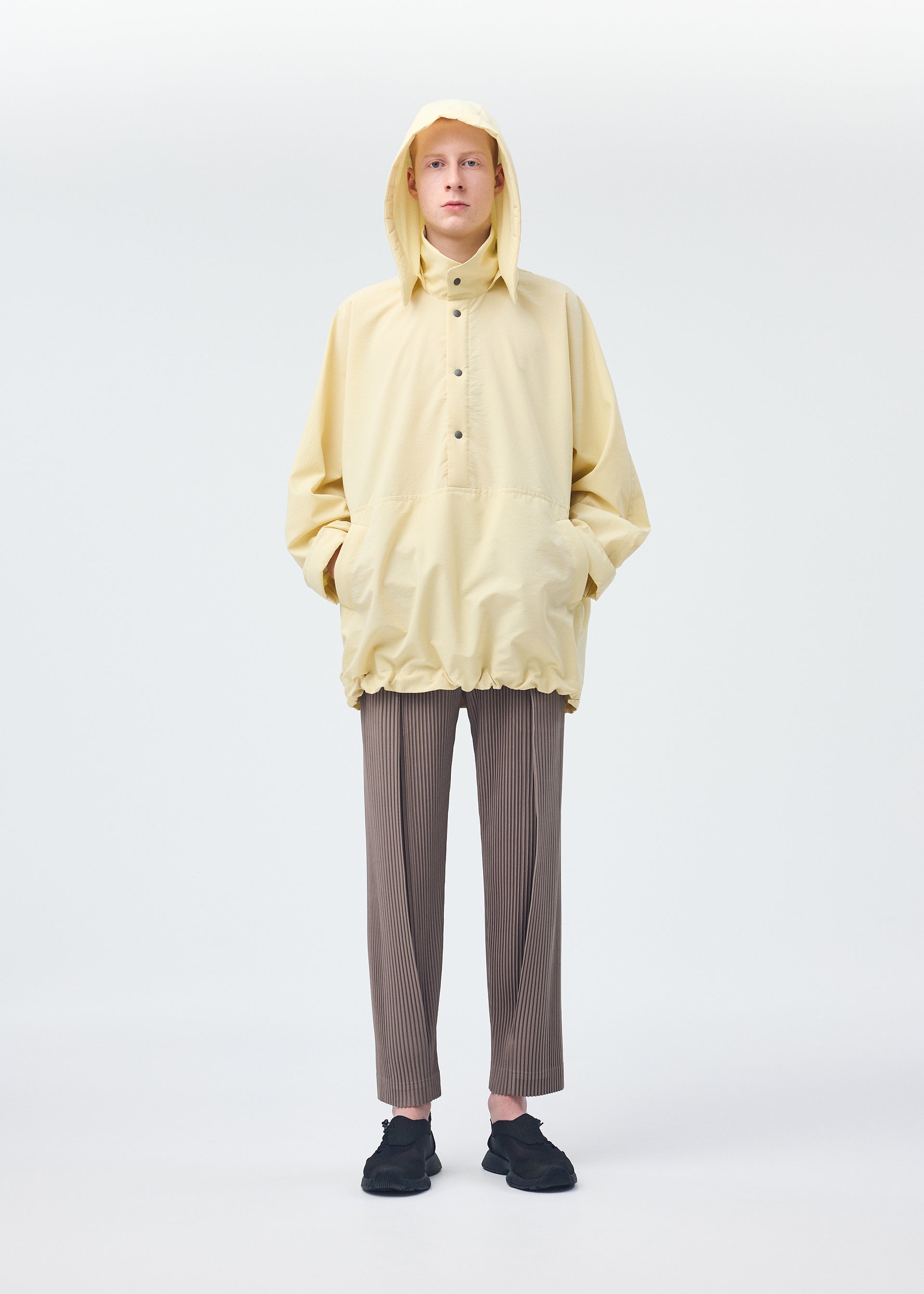 A model wears the HOMME PLISSÉ ISSEY MIYAKE PADDED RIM SHIRT shirt.