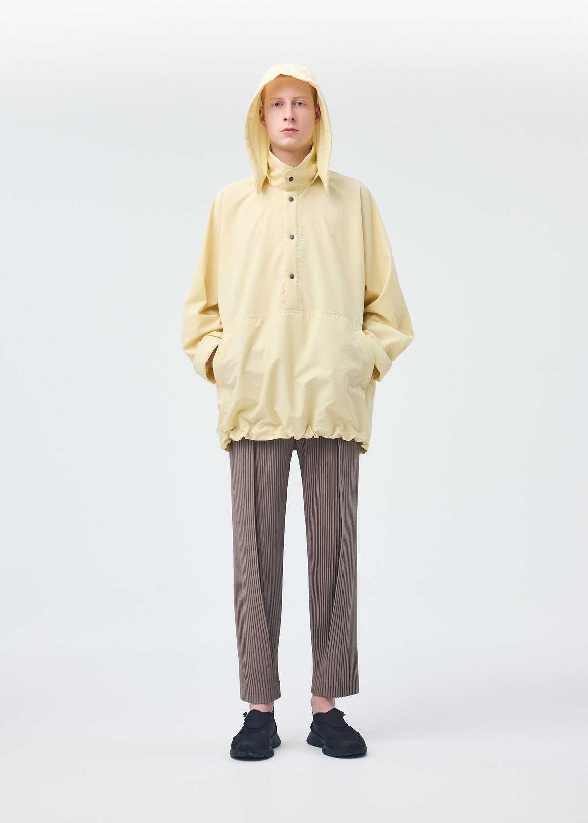 A model wears the HOMME PLISSÉ ISSEY MIYAKE PADDED RIM SHIRT shirt.